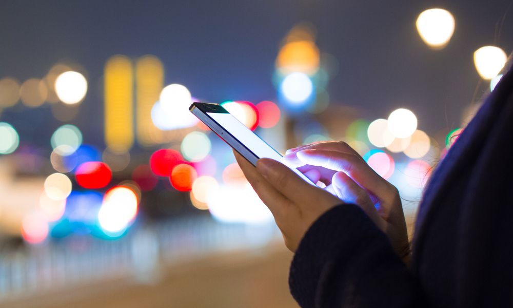 Woman Using Mobile Phone At Night Street