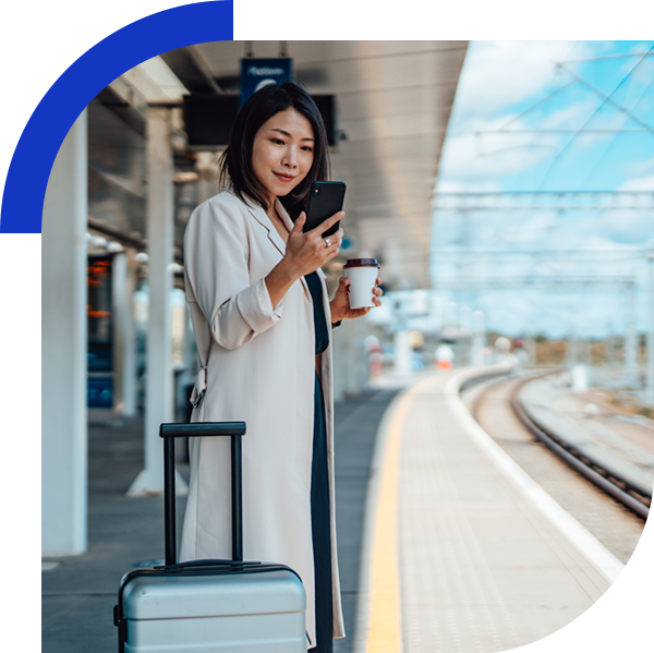 woman on phone waiting for a train at the platform